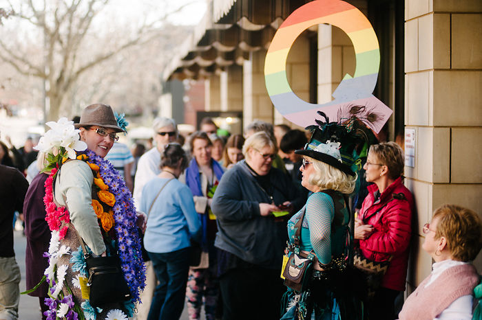 Fest-goers stand in the Q line and mingle outside the Missouri Theatre